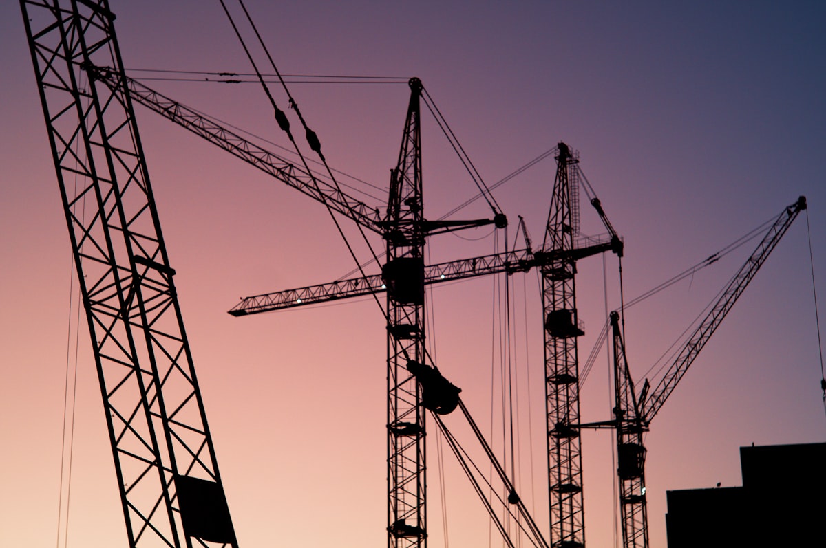 Gruas de obra recortadas contra o céu