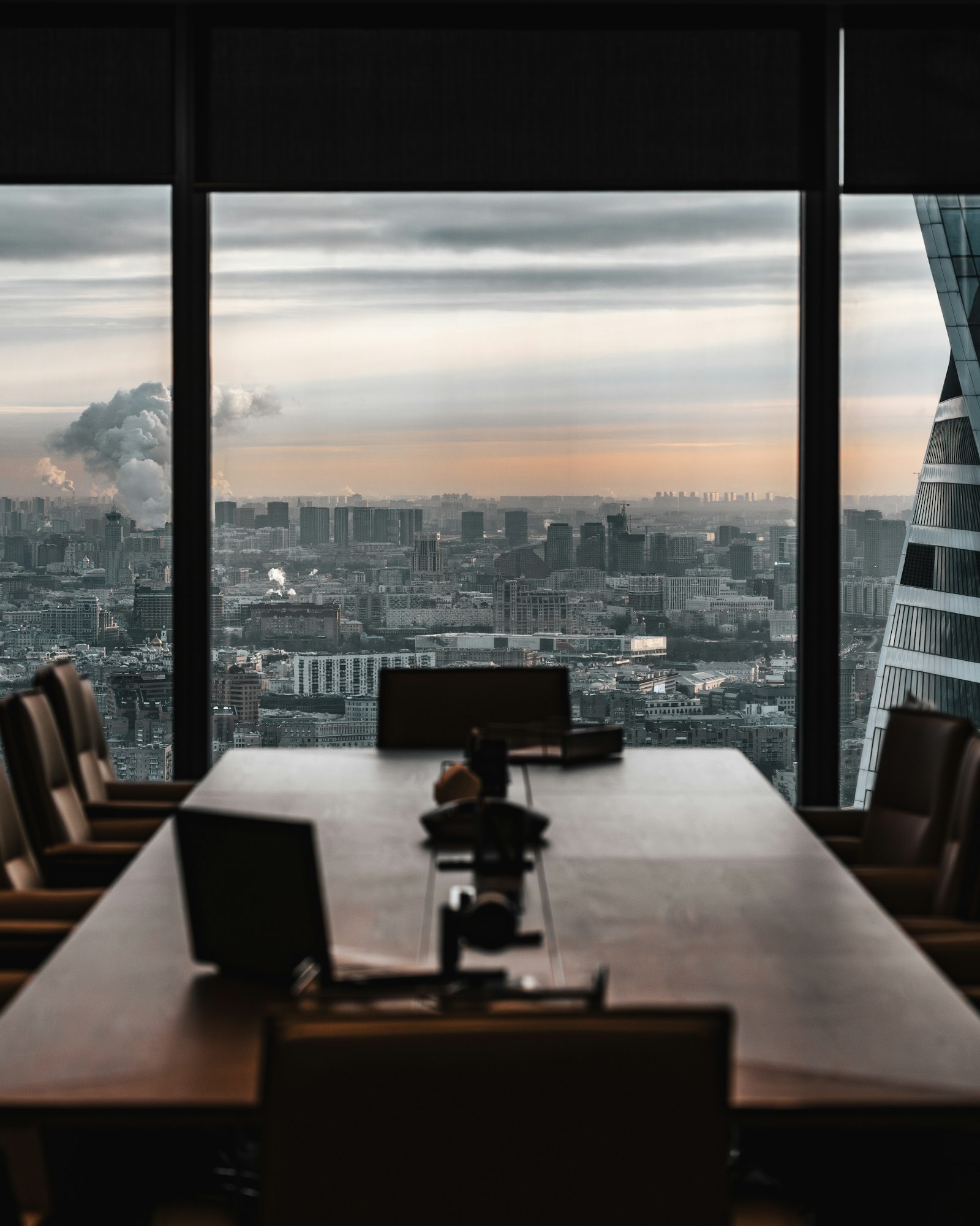 Mesa de reunião diante de uma janela com vista para a cidade